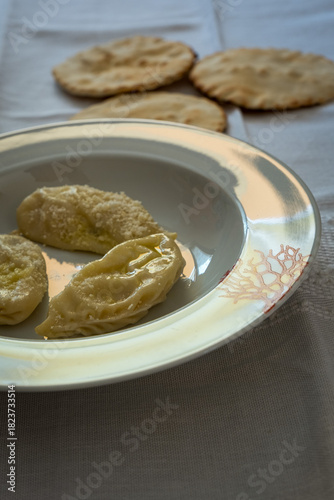 Homemade traditional Sardinian pasta called Culurgiones on a porcelain plate