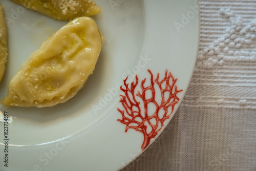Homemade traditional Sardinian pasta called Culurgiones on a porcelain plate