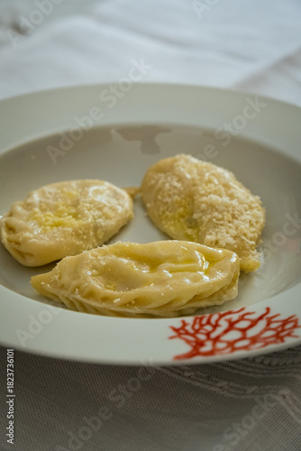 Homemade traditional Sardinian pasta called Culurgiones on a porcelain plate