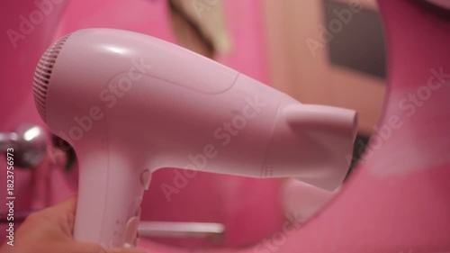 Hair Dryer Working Medium Fan Mode with Sound, Modern Bathroom Interior Pink Walls Background, Hair Styling Technology Device, Domestic Comfort Appliance Operation, Personal Care Routine