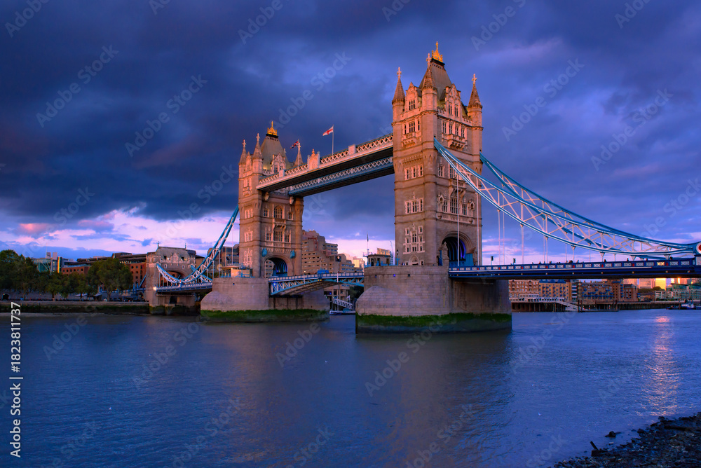 Obraz premium Tower Bridge, the iconic landmark of London spanning the River Thames, captured in a romantic moment. The elegant structure, illuminated against the water.