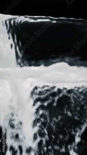 Backlit macro video: clear water becoming pure white liquid, flowing horizontally on black, showcasing intricate fluid dynamics. Abstract scientific concept