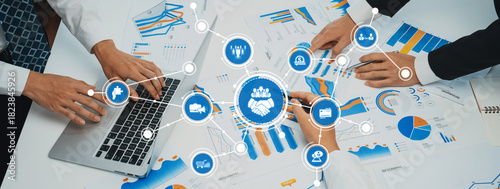 A professional team collaborates during a business meeting, analyzing data charts and utilizing laptops to strategize and discuss key insights for project success. Amity