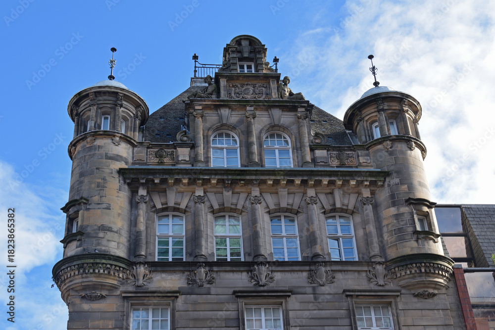 Fototapeta premium Facade of Ornate Victorian Stone Office Building with Turrets seen from Below 