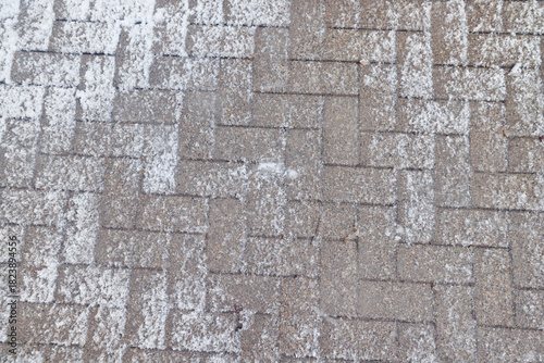 Winter texture of paving slabs covered with snow, top view, background surface in snow