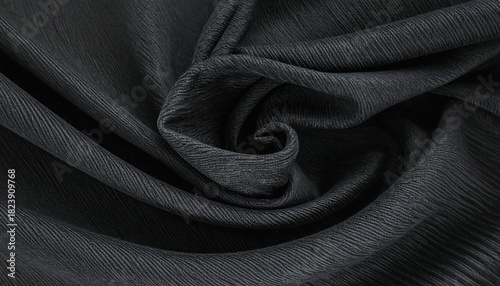 A close-up of draped dark fabric with a swirling fold at its center, showcasing subtle linear texture across the surface