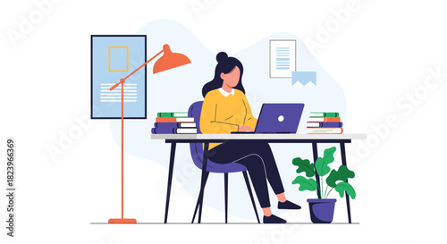 Young woman working or studying on a laptop at her desk in a modern home office with books a plant and a desk lamp.