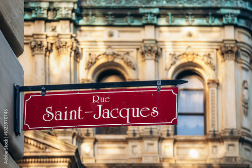 Street sign of Rue Saint-Jacques in downtown Montreal with historic architecture in soft evening light