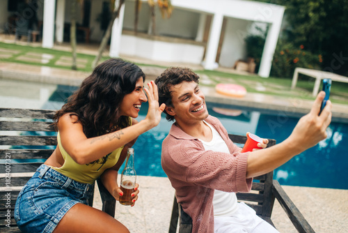 Fotografi Friends take selfie by pool during sunny day