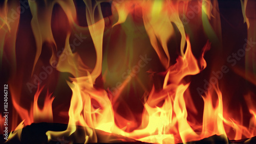 Close up view of warm orange fireplace flames flickering over dark logs, creating a cozy glowing background for winter relaxation, holidays and home comfort.