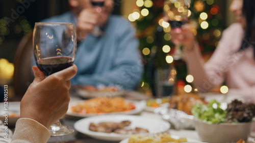 Group of Asia colleague gathering New year holidays party together. Close-up Happy friends group drink glasses of wine start eat christmas dinner at home in evening, celebration and people concept.