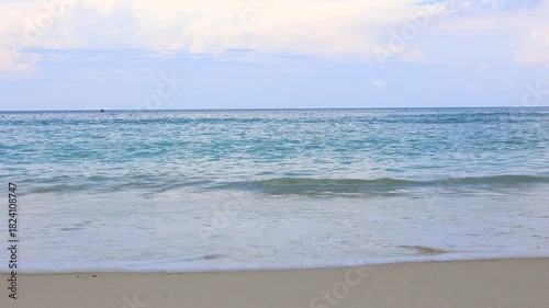 Calm tropical shoreline view, idyllic beachscape with soothing waves and pastel sky backdrop.