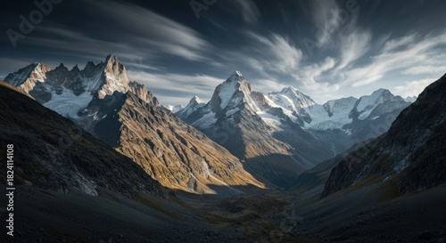 Dramatic view of high, snow-capped peaks in a deep mountain valley