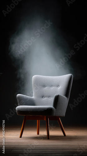 Gray upholstered armchair on wooden floor with mist