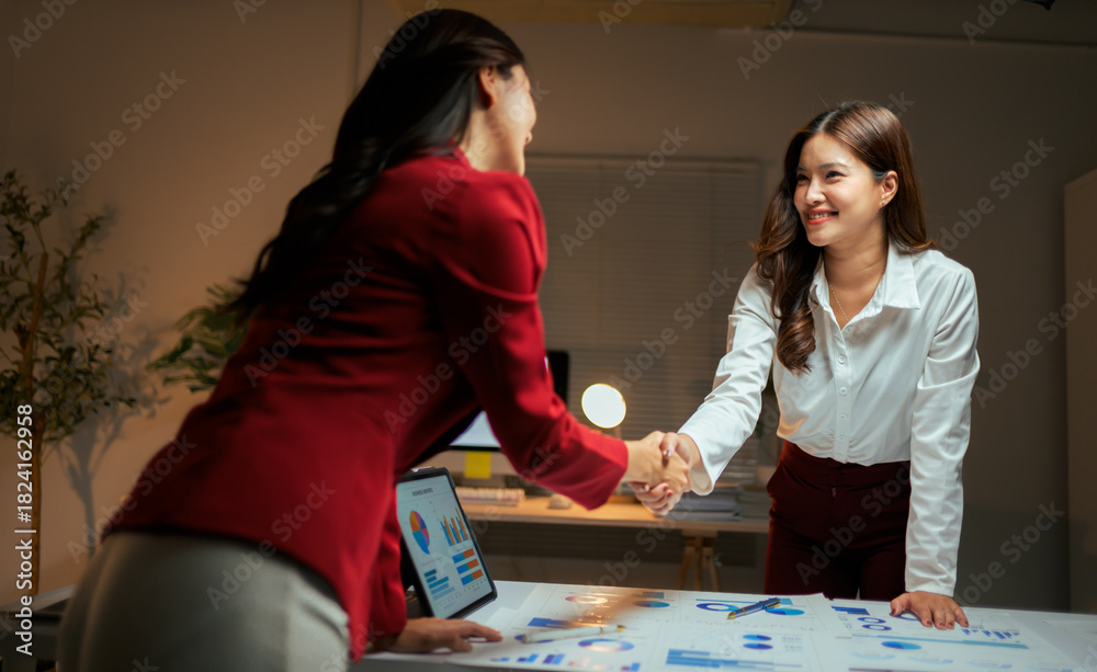 Fototapeta premium Businesswomen shaking hands completing a successful deal at office