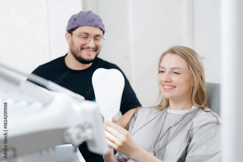 Obraz premium Caucasian female patient smiling at dent office with male dentist, consultation in stomatology clinic