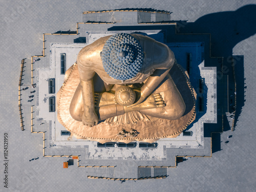 Aerial view of the gilded, gigantic Buddha Dordenma statue radiates against the muted grays of its platform, a spiritual sentinel overlooking the valley, Thimphu, Thimphu, Bhutan.