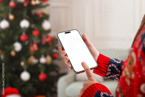 Christmas-themed phone mockup with hand tapping the screen, perfect for mobile app previews, winter marketing, festive designs and holiday promotions