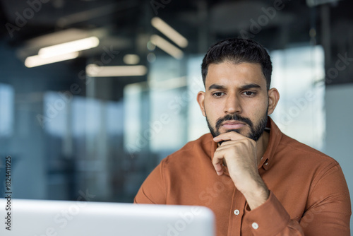 Fotografía Young bearded man feeling pensive and concentrated, holding chin while looking a