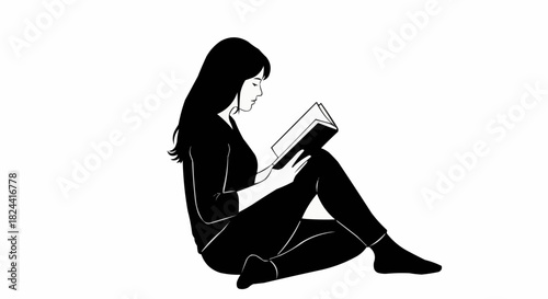 Woman engrossed in reading a book while sitting on the floor.