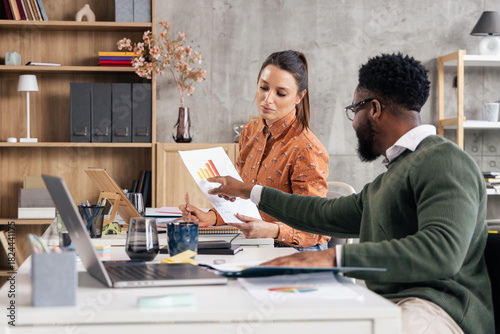 Diverse business colleagues analyzing chart data in office meeting