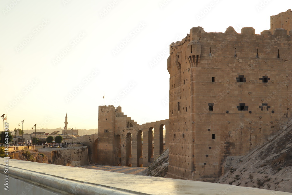 Fototapeta premium Aleppo, Syria. Majestic stone towers of the Citadel of Aleppo, world’s oldest and largest castle. UNESCO World Heritage site reflecting Islamic medieval architecture, power, timeless history