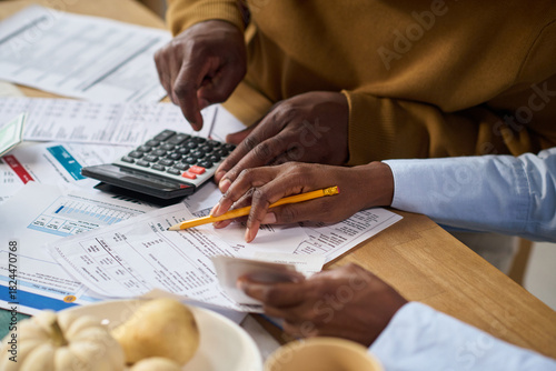 Quadro su tela Closeup of Black man and Black woman calculating taxes together using calculator