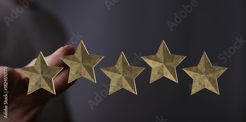 A hand presents five golden...