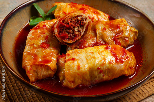 Stuffed cabbage rolls with minced meat, in tomato sauce, top view, without people, in the spotlight.
