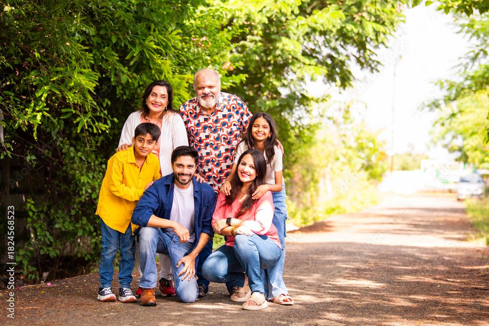 Fototapeta premium Indian family bonding happily while standing outdoors and smiling together