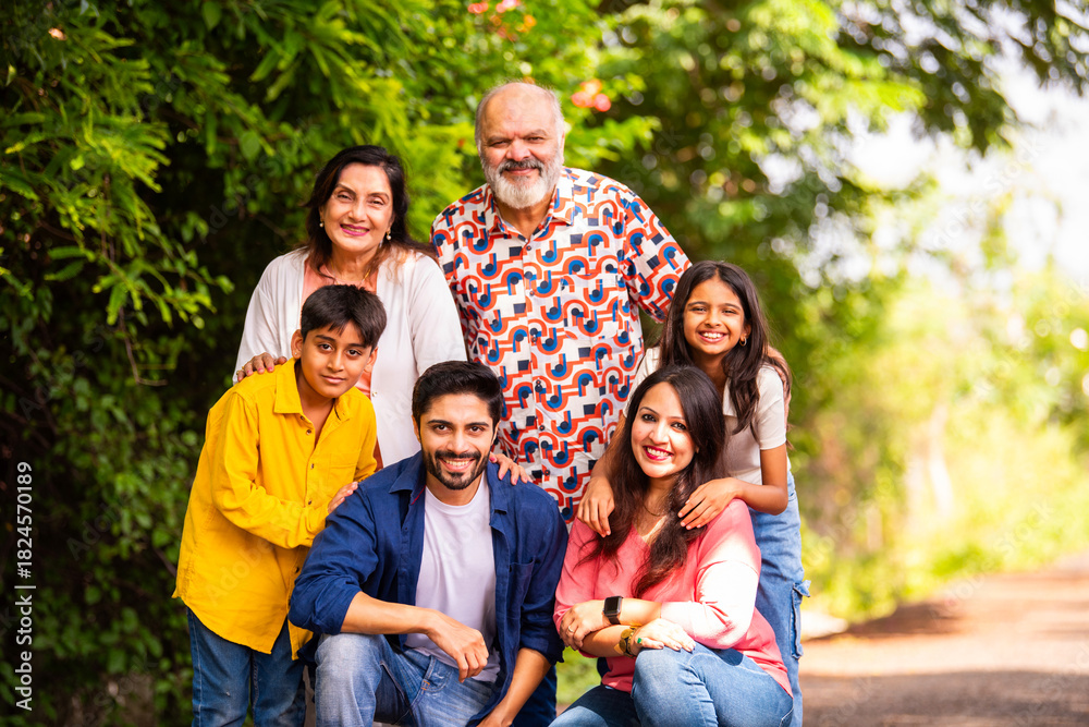 Fototapeta premium Indian family bonding happily while standing outdoors and smiling together
