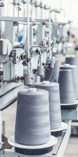Spools of gray thread on factory machine