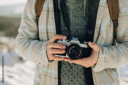 Person holding vintage film camera outdoors