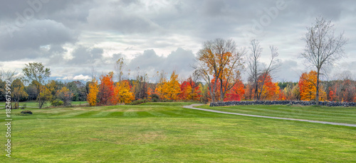 A beautiful golf course with coloured fall foliage on a cloudy autumn day in Canada