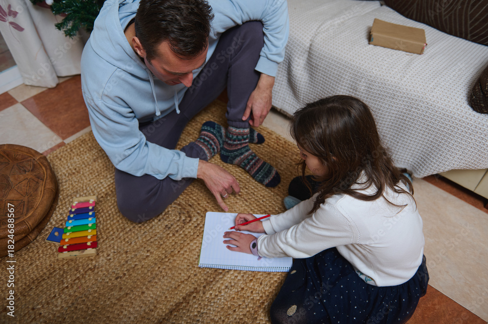 Obraz premium Father And Daughter Draw Together At Home For A Cozy Family Moment