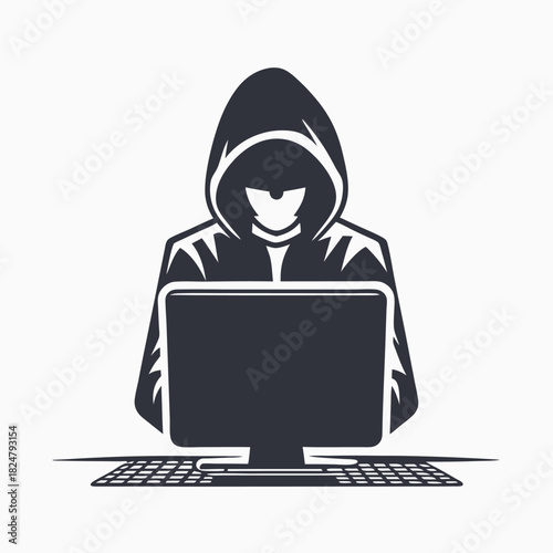 Shadowy hooded figure intently uses a computer keyboard in front of an obscured monitor