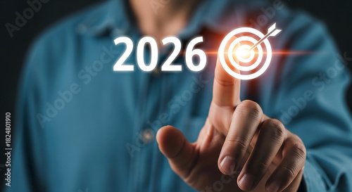 A person s finger touches the year 2026 overlaid with a glowing target symbol representing future goals and aspirations for the upcoming year