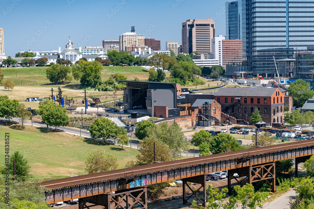 Naklejka premium Wide landscape photograph capturing the contrast between Richmond's modern glass skyscrapers and the natural beauty of the James River Park System.
