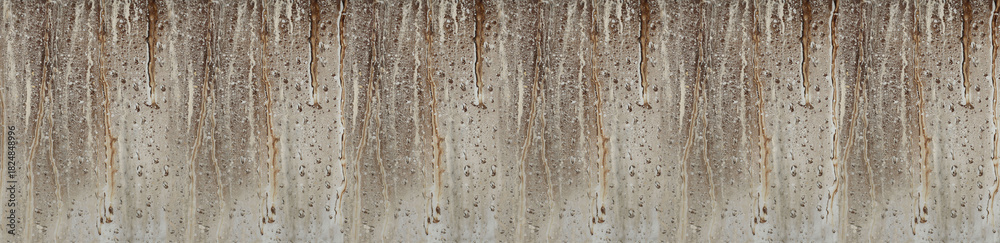 Obraz premium Weathered concrete wall with brown rust stains and dripping patterns creating natural vertical texture background