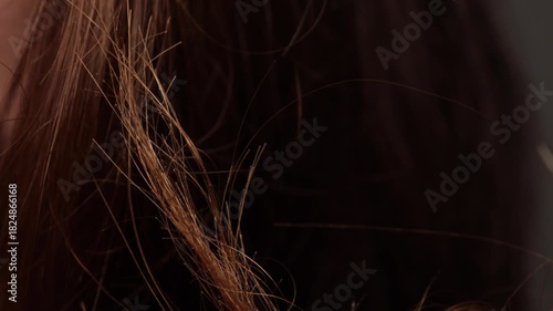 Closeup view of damaged hair strands with visibly split ends showing dryness, breakage and unhealthy hair texture