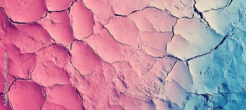 Aerial view of cracked earth surface with pink and blue hues creating an abstract landscape look