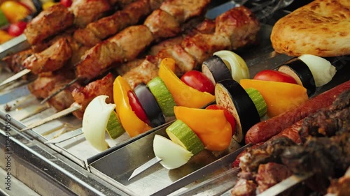 A platter of grilled skewers of marinated meat paired with vibrant vegetables including bell peppers, zucchini, onions, and tomatoes