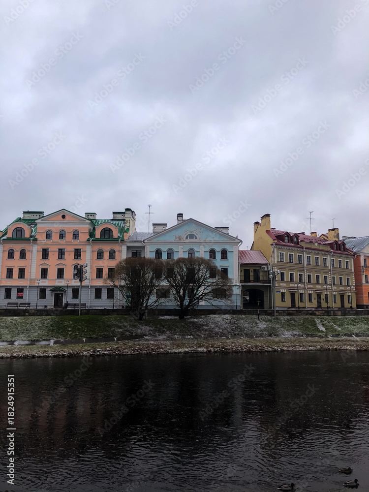 Obraz premium Winter scene along the Pskova River embankment in the city of Pskov, Russia. The Golden Embankment covered in snow creates a calm atmosphere, concept of seasonal tourism and cold weather charm.
