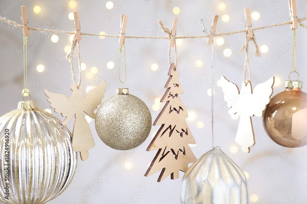 Obraz premium Beautiful Christmas decor hanging on string against blurred lights