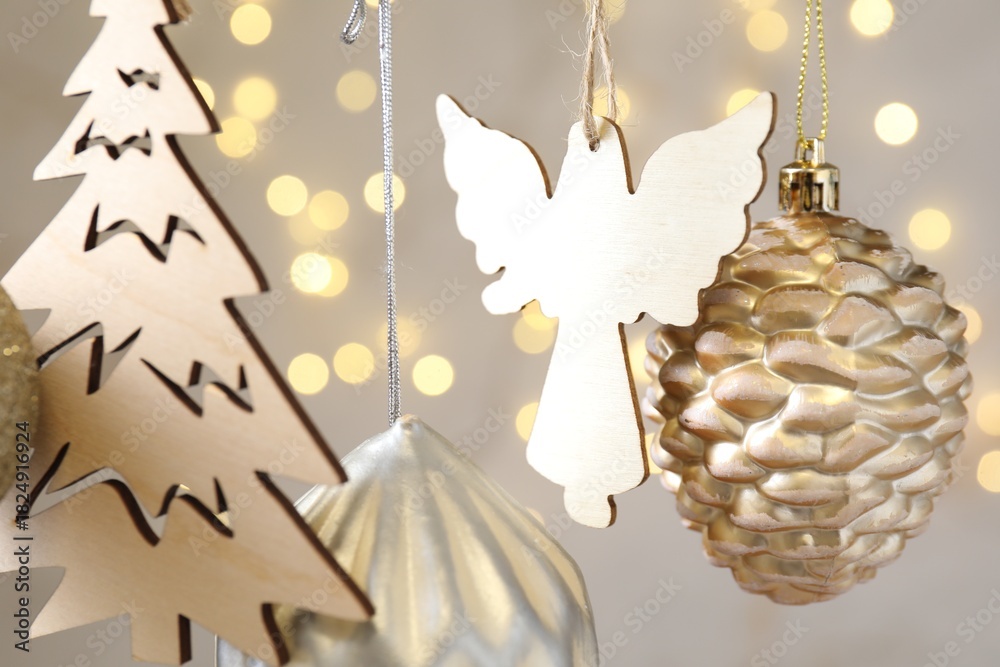 Fototapeta premium Beautiful Christmas decor hanging on string against blurred lights, closeup