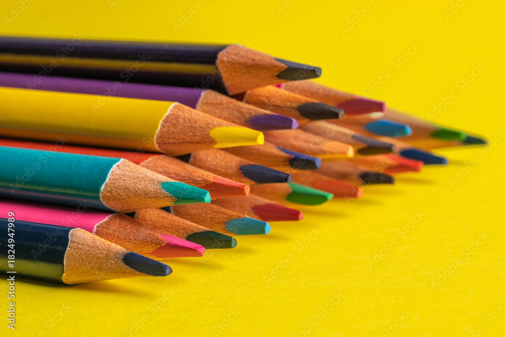 Fototapeta premium colored pencils on a yellow background