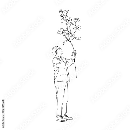 Man holding a tall flowering plant, looking up
