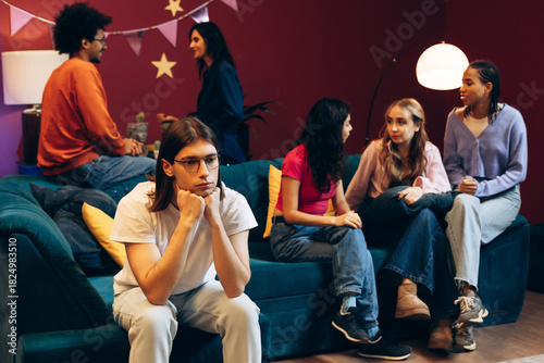 Introverted young man feeling excluded at a social gathering