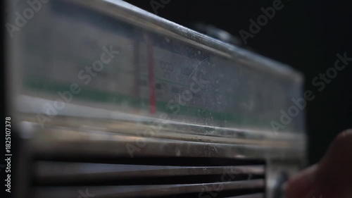 Adjusting frequency on a retro analog radio with the moving frequency bar clearly visible, showcasing vintage tuning interaction and signal search.