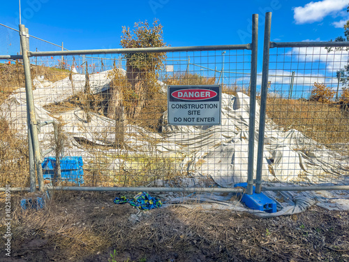 Photograph of a Danger Warning Sign on a fence barricade notifying people not to enter a small construction site in regional New South Wales, Australia. 